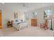 Light filled bedroom featuring carpet, a ceiling fan, three windows, and cozy furniture at 109 Chimeneas Pl, Chapel Hill, NC 27517