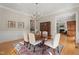 Traditional dining room with a chandelier, wood floors, and a view into the living room at 109 Chimeneas Pl, Chapel Hill, NC 27517