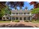 Stately home with a large front porch, dormer windows, and a well-manicured lawn and circular brick driveway at 109 Chimeneas Pl, Chapel Hill, NC 27517