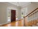 Bright foyer with hardwood floors, a staircase, and a view of the front yard through the glass-paneled front door at 109 Chimeneas Pl, Chapel Hill, NC 27517