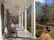 Relaxing front porch with rocking chairs and views of the well-manicured landscaping and circular driveway at 109 Chimeneas Pl, Chapel Hill, NC 27517