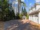 Paver driveway leading to three-car garage with small dog run at 109 Chimeneas Pl, Chapel Hill, NC 27517