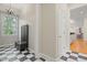 Hallway featuring black and white checkered floors, coat rack bench, and view of kitchen at 109 Chimeneas Pl, Chapel Hill, NC 27517