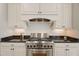 Kitchen with stainless steel gas range, subway tile backsplash, and custom white cabinets at 109 Chimeneas Pl, Chapel Hill, NC 27517