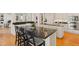 Kitchen island with barstool seating, granite countertops, and white cabinetry at 109 Chimeneas Pl, Chapel Hill, NC 27517