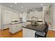 Bright kitchen with white cabinetry, black countertops, and modern stainless steel appliances at 109 Chimeneas Pl, Chapel Hill, NC 27517