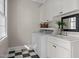 Bright laundry room with white cabinetry, countertop, sink, and a modern washer and dryer at 109 Chimeneas Pl, Chapel Hill, NC 27517