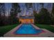 Backyard pool and poolhouse with a brick border and concrete surround at 109 Chimeneas Pl, Chapel Hill, NC 27517