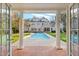A view of the backyard pool and patio from an open doorway, framed by columns at 109 Chimeneas Pl, Chapel Hill, NC 27517