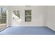 Bright room with blue flooring, a large window, and a sliding glass door offering outdoor views at 109 Chimeneas Pl, Chapel Hill, NC 27517