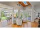 Bright sitting room with skylights, wood ceiling, hardwood floors, and backyard access at 109 Chimeneas Pl, Chapel Hill, NC 27517