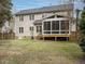 Backyard featuring a screened-in porch, lush green grass and mature trees at 110 Forest Run Pl, Cary, NC 27518