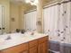 Bathroom showcasing a double sink vanity with framed mirror and shower with a decorative curtain at 110 Forest Run Pl, Cary, NC 27518