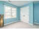 Bright blue bedroom filled with natural light from a large window and a double door closet at 110 Forest Run Pl, Cary, NC 27518