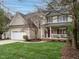 Traditional two-story home featuring a green lawn, a two-car garage, and a welcoming front porch at 110 Forest Run Pl, Cary, NC 27518