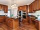 Gourmet kitchen with dark wood cabinets, granite countertops, and stainless steel appliances at 110 Forest Run Pl, Cary, NC 27518