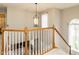 Staircase featuring white railings and wood trim, illuminated by a hanging light fixture at 110 Forest Run Pl, Cary, NC 27518