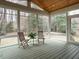 Inviting sunroom with wooden floors and furniture, surrounded by large windows offering outdoor views at 110 Forest Run Pl, Cary, NC 27518