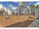 View of the backyard with a hill covered in leaves and trees at 110 Gulley Glen Dr, Garner, NC 27529