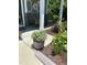 Relaxing front porch with wicker chairs, surrounded by lush greenery and colorful potted plants at 110 Gulley Glen Dr, Garner, NC 27529