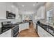 Open kitchen boasts stainless appliances, white cabinets and views to the living area at 110 Gulley Glen Dr, Garner, NC 27529