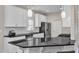 Bright kitchen with white cabinets, a black countertop island with bar stool seating, and stainless steel appliances at 110 Gulley Glen Dr, Garner, NC 27529