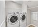 Modern laundry room featuring front loading washer and dryer and white wire shelving at 110 Gulley Glen Dr, Garner, NC 27529