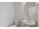 Half bathroom with toilet, sink, round mirror, and white walls at 111 Hickory Plains Rd, Knightdale, NC 27545
