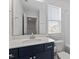 Bathroom featuring dark blue vanity, white countertop, mirror, and natural light at 111 Hickory Plains Rd, Knightdale, NC 27545