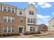 Beautiful three-story townhome with mixed brick and siding exterior, and manicured landscaping at 111 Hickory Plains Rd, Knightdale, NC 27545