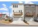 Modern townhomes with attached garages, a wooden balcony, and well-maintained lawns at 111 Hickory Plains Rd, Knightdale, NC 27545