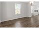 Bright living room with wood floors and large windows. Connected to kitchen at 111 Hickory Plains Rd, Knightdale, NC 27545