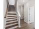 Elegant staircase with wooden steps, white risers, and a view of a hallway with white doors at 111 Hickory Plains Rd, Knightdale, NC 27545