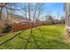 Spacious backyard with lush green grass, a wooden fence, and mature trees at 11342 Oakcroft Dr, Raleigh, NC 27614