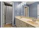 Bright bathroom with dual sink vanity, mirror, tile floor, with a view to a bath and toilet at 11342 Oakcroft Dr, Raleigh, NC 27614