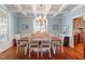 Bright dining room with a coffered ceiling, hardwood floors, and classic chandelier at 11342 Oakcroft Dr, Raleigh, NC 27614