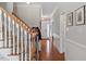 Inviting hallway with hardwood floors, staircase with wooden banister, and decorative wall paneling at 11342 Oakcroft Dr, Raleigh, NC 27614