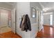 Hallway featuring hardwood floors, coat hooks, and access to a laundry room and front entry at 11342 Oakcroft Dr, Raleigh, NC 27614