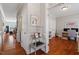 Hallway with hardwood floors leading to an office and living spaces, adorned with artwork at 11342 Oakcroft Dr, Raleigh, NC 27614