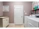 Functional laundry room with modern appliances, a sink, and storage shelves for organization at 11342 Oakcroft Dr, Raleigh, NC 27614