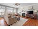 Cozy living room with a fireplace, plush seating, and a ceiling fan for added comfort at 11342 Oakcroft Dr, Raleigh, NC 27614