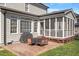 Outdoor patio with a grill, table, and chairs next to a screened-in porch and manicured lawn at 11342 Oakcroft Dr, Raleigh, NC 27614