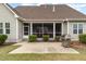 The back of the home features a screened in porch, patio, stainless grill, and manicured landscaping at 121 Stone Nut Trl, Fuquay Varina, NC 27526