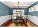 Elegant dining room with coffered ceilings, wainscoting, a modern chandelier, and natural light at 121 Stone Nut Trl, Fuquay Varina, NC 27526