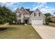 Charming two-story home featuring a manicured lawn and a spacious two-car garage at 121 Stone Nut Trl, Fuquay Varina, NC 27526