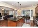 Open kitchen with island seating, stainless appliances and views to the dining and living areas at 121 Stone Nut Trl, Fuquay Varina, NC 27526