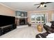 Comfortable living room features a stone fireplace, large TV, and leather sofa at 121 Stone Nut Trl, Fuquay Varina, NC 27526