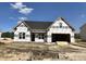 Under-construction single-Gathering home featuring a black roof and an attached two-car garage at 123 Pretty Run Branch Ln, Wendell, NC 27591