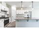 Modern kitchen featuring white cabinets, granite countertops, stainless steel appliances, and stylish pendant lighting at 123 Pretty Run Branch Ln, Wendell, NC 27591
