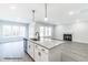 Open-concept kitchen with a large island, stainless steel appliances, and views of the living room with a fireplace at 123 Pretty Run Branch Ln, Wendell, NC 27591